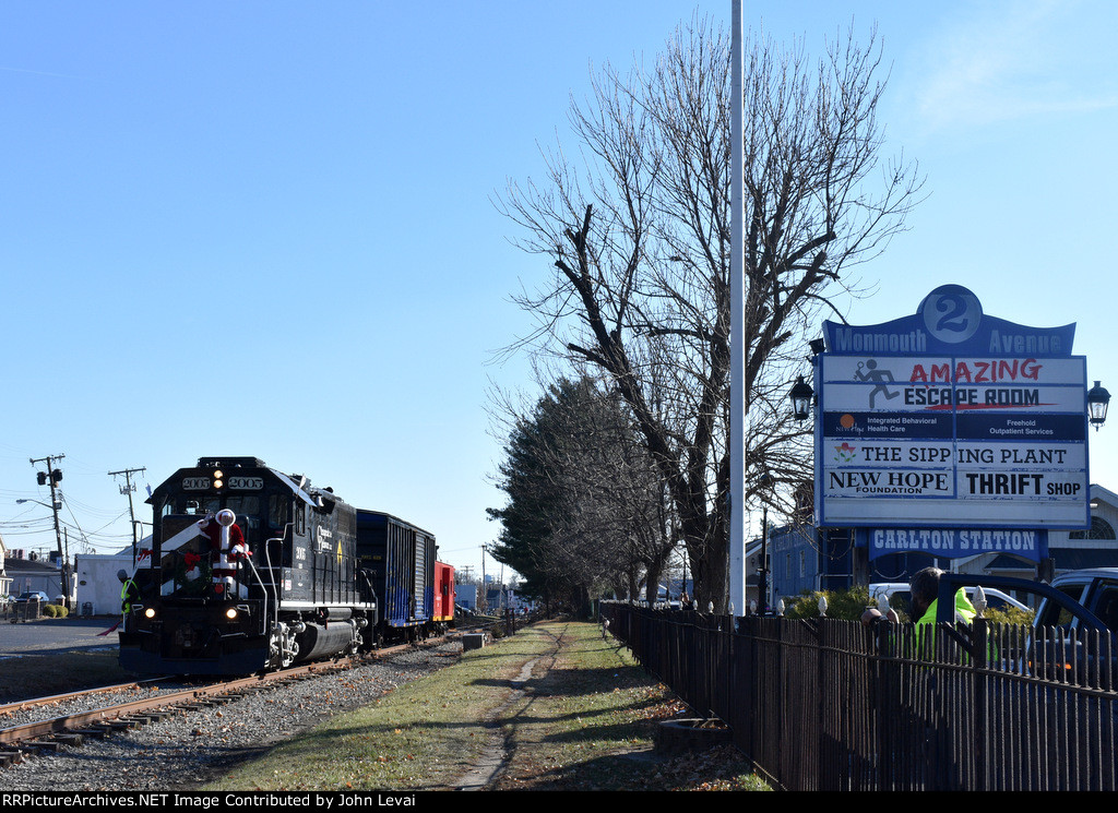 The 2003 leading the DRR TFT train past the 2 Monmouth Avenue Shopping Center sign in Freehold